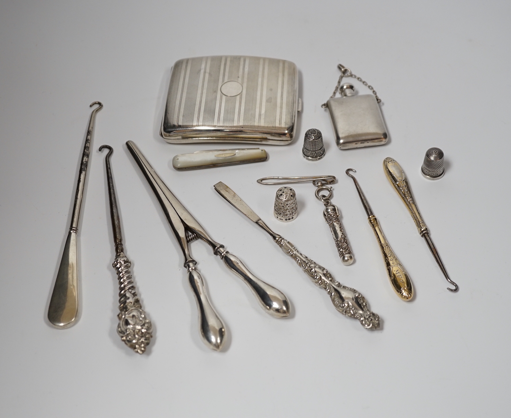 A George V silver cigarette case, Adie Bros. Birmingham, 1929, two silver and two sterling mounted button hooks and seven other items including propelling pencil in case, fruit knife and Italian 800 standard scent flask.